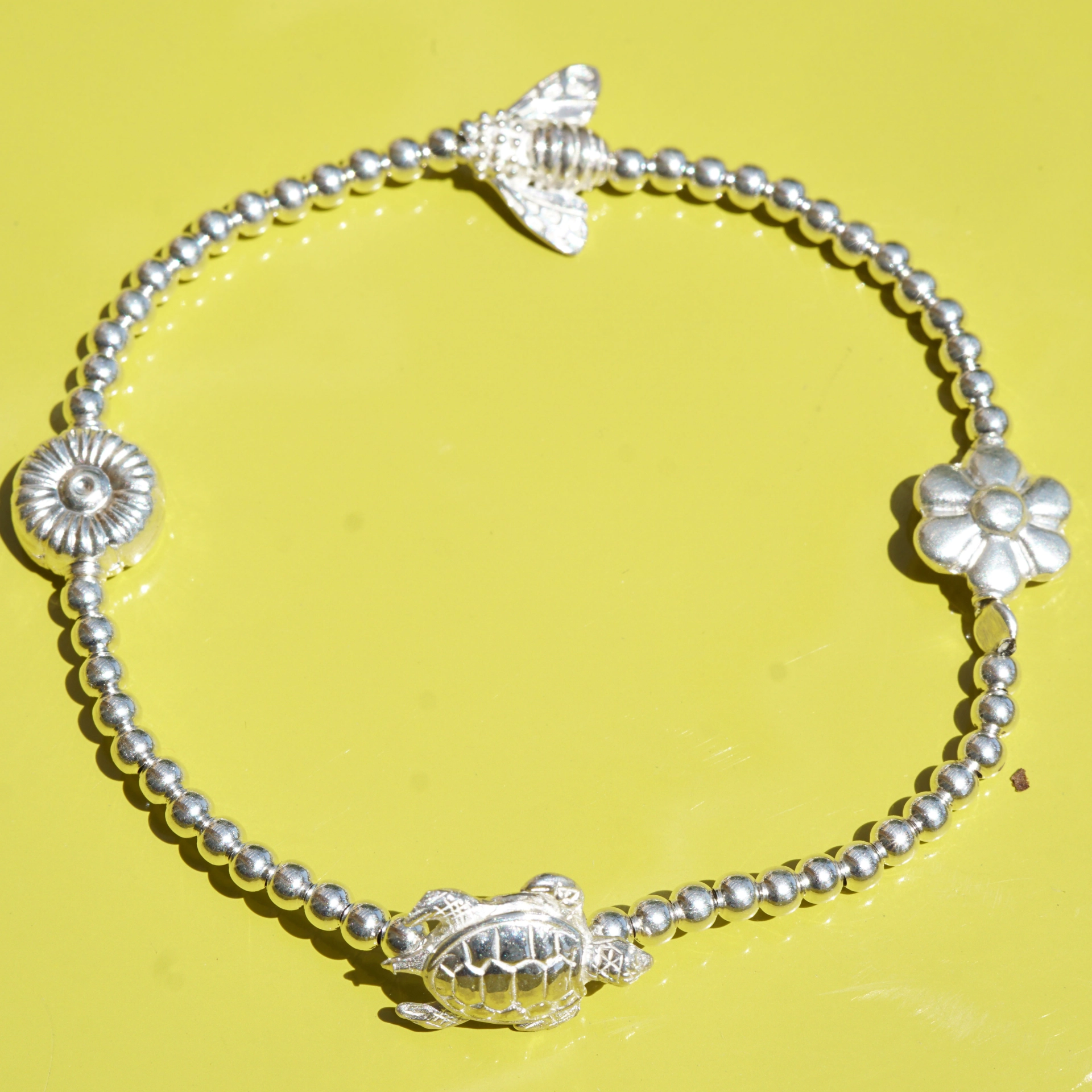 Chilango Armband elastisch Kugeldesign Silber süsse Motive (Schildkröte, Biene, Margerite, Herz )